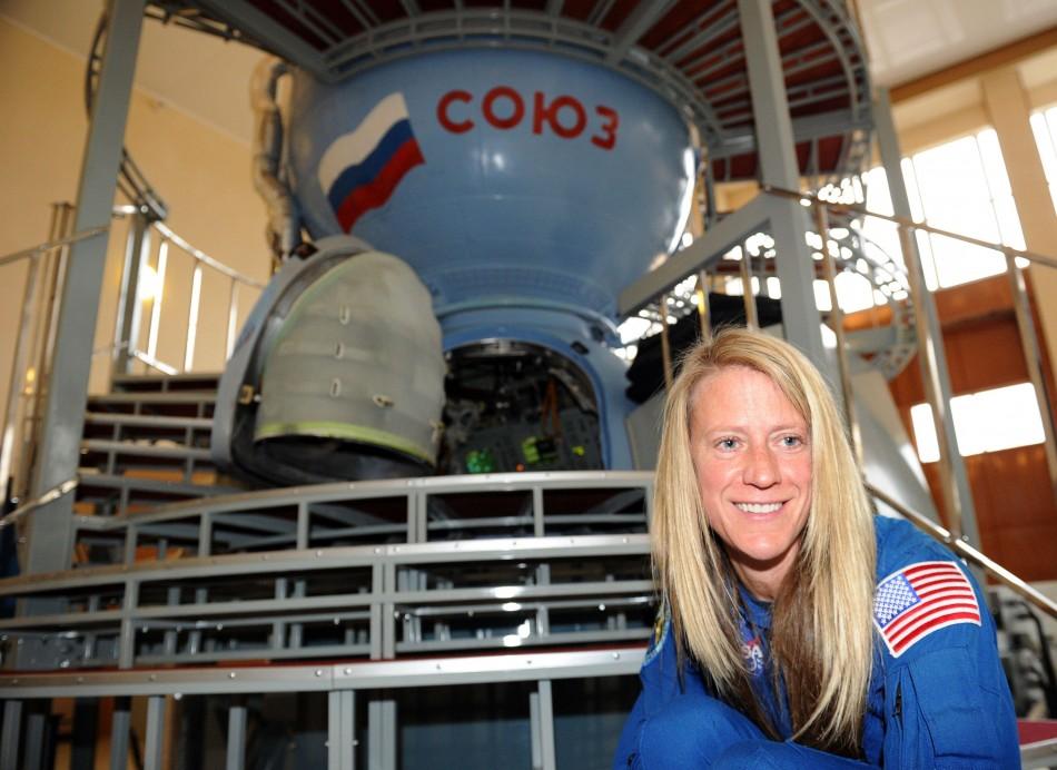 A astronauta Karen Nyberg sorri na frente de uma nave espacial Soyuz, no centro de treinamento de cosmonautas na Cidade das Estrelas, perto de Moscou (France Press)