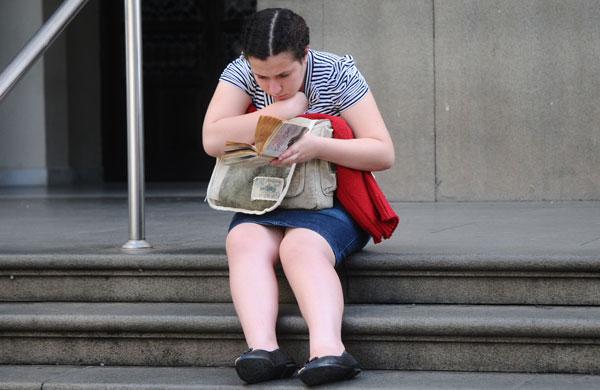 Concentrada em sua leitura nas escadarias da Catedral (Camila Moreira/AAN)