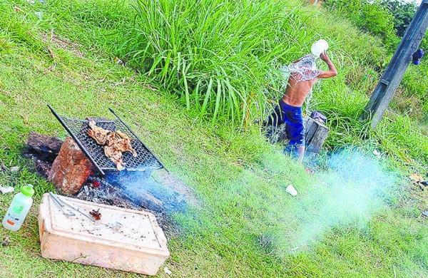 Morador de rua toma banho enquanto a carne assa na churrasqueira (Maurício R. Martins/Jornal de Limeira)