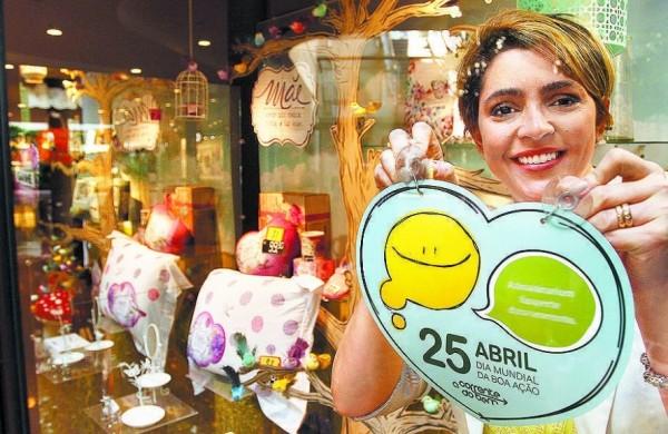 A empresária Camila Geraldes Magalhães fixa cartaz da campanha em vitrine (Gustavo Tílio/ Especial para AAN )