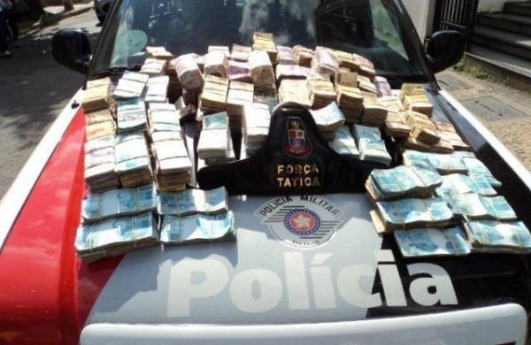 Dinheiro apreendido ficou exposto em cima de carro da polícia (Divulgação)