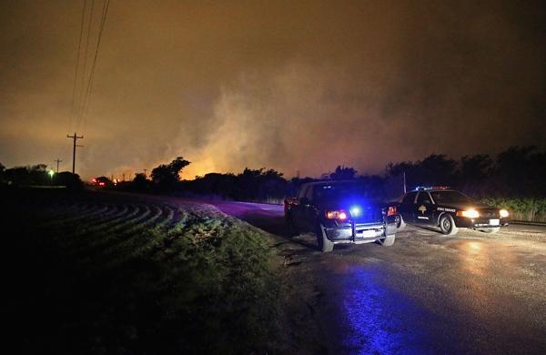 Polícia do Texas bloqueia estrada; ao fundo fogo consome fábrica de fertilizantes (France Press)
