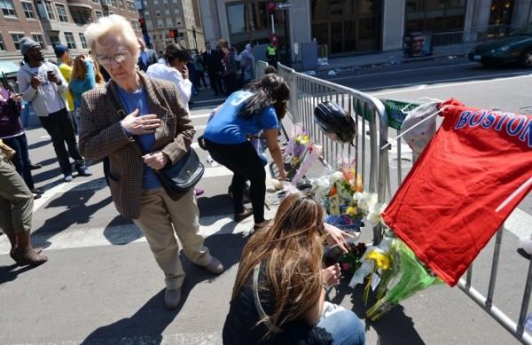 As pessoas deixam suas homenagens às vítimas do atentado em Boston, no local da maratona onde ocorreram duas explosões (France Press)