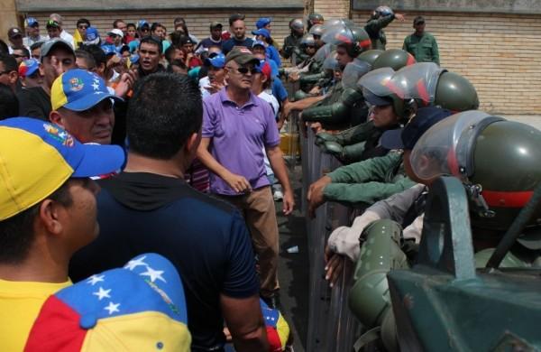 Policiais venezuelanos fazem cinturão de segurança para conter manifestantes em Caracas (France Press)