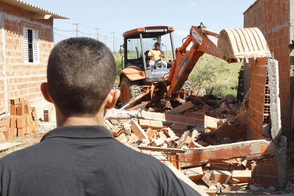 Morador observa funcionário demolir casa com retroescavadeira (Gustavo Tilio/Especial para AAN)