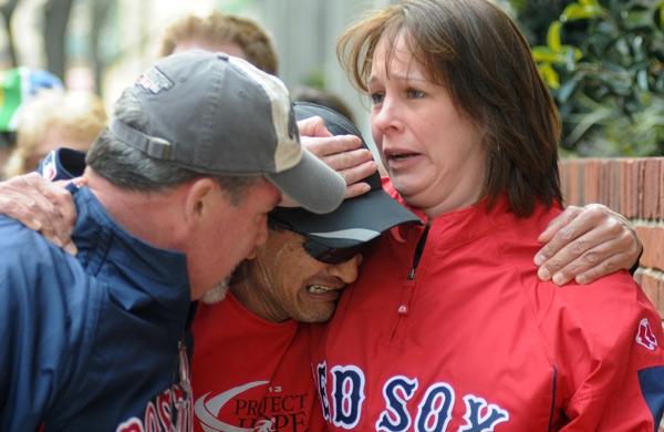 O maratonista John Ounao chora ao se encontrar com amigos após várias explosões próximas à linha de chegada da Maratona de Boston, em Massachusetts, nesta segunda-feira (15) (France Presse)
