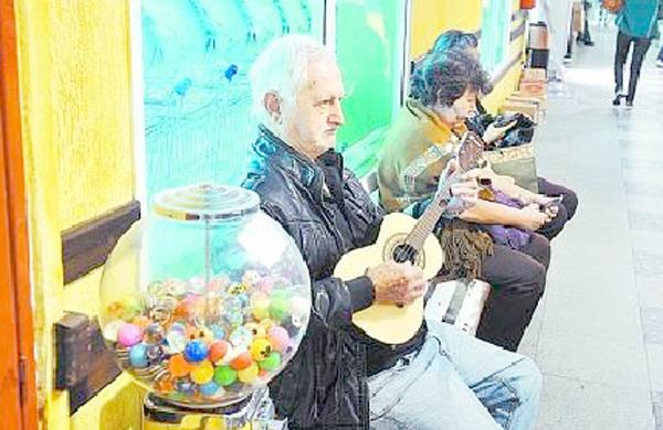 Ângelo Baena toca seu cavaquinho em mercado (Dominique Torquato)