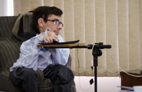 Descrição da imagem: o psicólogo Claudio Dusik está sentado, digitando em um computador. Ele tem atrofia muscular, que deixam seus braços e pernas curtos (Tô Dentro!)