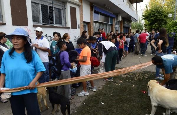 Vítimas das inundações na Argentina fazem fila para receber água, alimento e roupas (France Press)