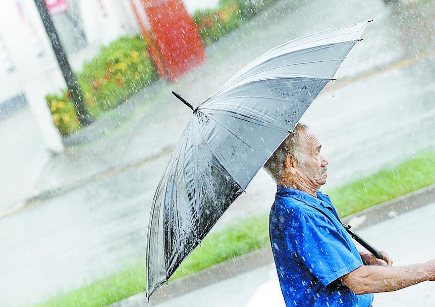 Idoso se protege da chuva durante a manhã desta terça-feira em Piracicaba (Del Rodrigues/AAN)