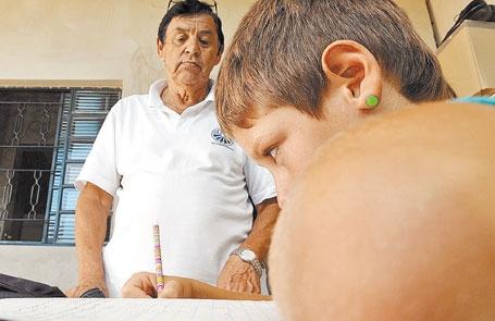 Expedito Corrêa da Silva orienta o neto, W.C., de 13 anos, a fazer a lição de casa em Campinas: "a gente conversa e diz que ele vai conseguir" (Edu Fortes/AAN)