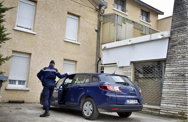 Policial francês vistoria veículo em frente à residência onde corpos foram encontrados (France Press)