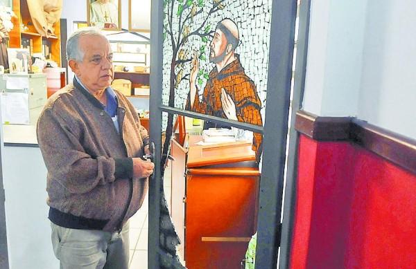 Padre Carlos Roberto da Silva mostra porta da igreja com vitral quebrado: 2º arrombamento em oito anos (Dominique Torquato/ AAN )