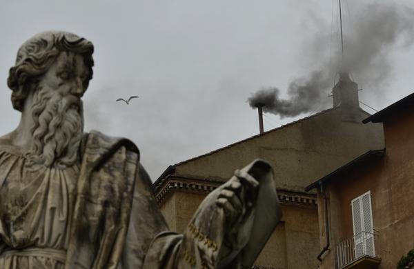 Fumaça preta sobe por chaminé da Capela Sistina, atrás da estátua de São Paulo (France Press)