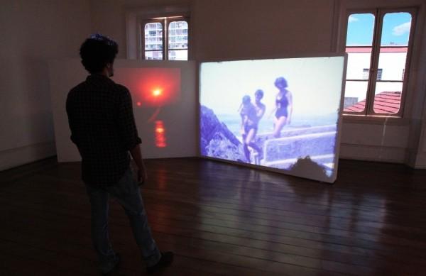 Rapaz observa uma das obras da exposição Vestígios, em cartaz no Museu da Imagem e do Som em Campinas ( Leandro Ferreira/AAN)