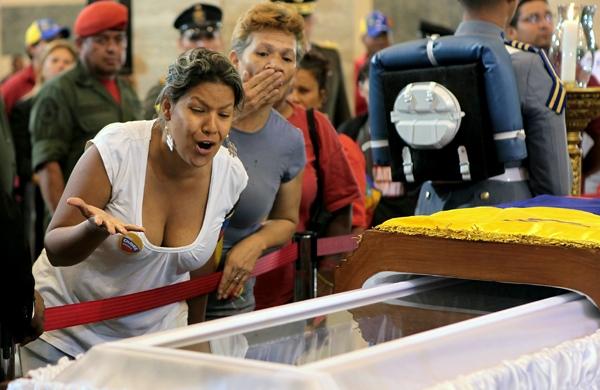 Venezuelana lamenta a morte de Hugo Chávez ao lado do caixão do presidente (France Press)