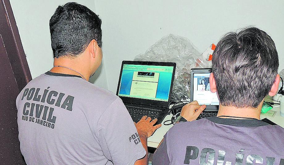 Policial civil do Rio de Janeiro (à direita) analisa imagens no notebook do acusado de pedofilia em Piracicaba (Ana Cristina Andrade)