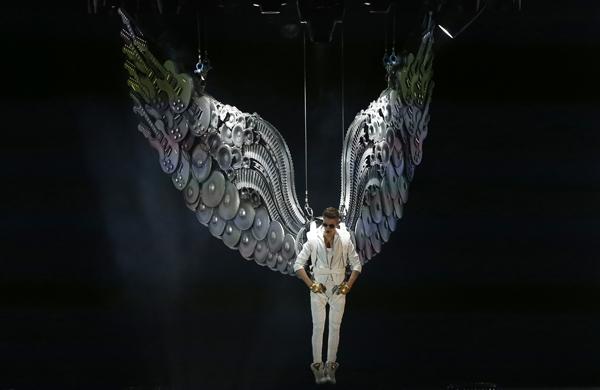 Justin Bieber durante introdução de seu show quando o cantor chega "voando" com asas (France Press)