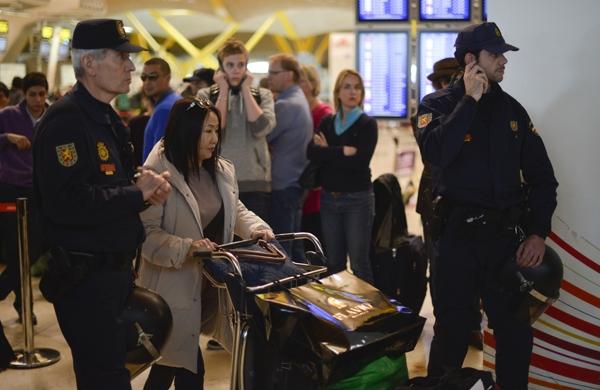 Passageiros e policiais espanhois observam protesto de funcionários da Iberia (France Press)