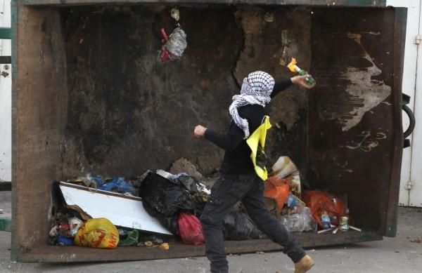 Homem mascarado participa dos protestos contra a morte de prisioneiro palestino em uma prisão israelense (France Press)
