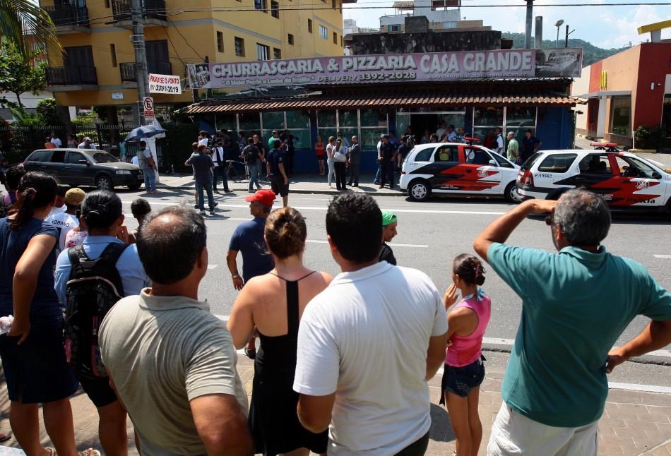 Pessoas acompanham a movimentação em frente ao restaurante Casa Grande (Rogério Soares/Tribuna de Santos)