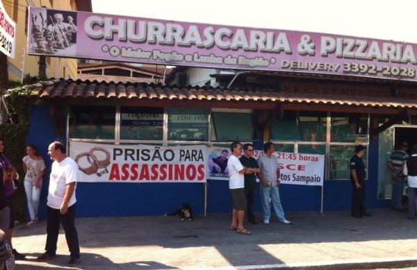 O pai de Mário Sampaio acompanha a ação do lado de fora da churrascaria com uma faixa escrito: 'Prisão aos assassinos' (Rogério Soares/A Tribuna)