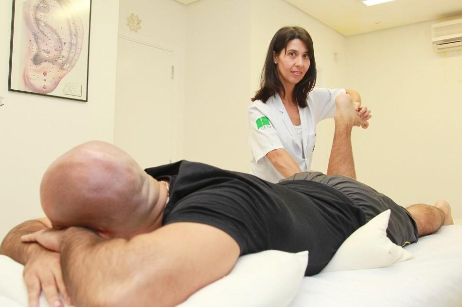 A fisioterapeuta Luciana Vinagre aplica a técnica de massagem desportiva no corredor Rodrigo Xavier ( Leandro Ferreira/AAN)