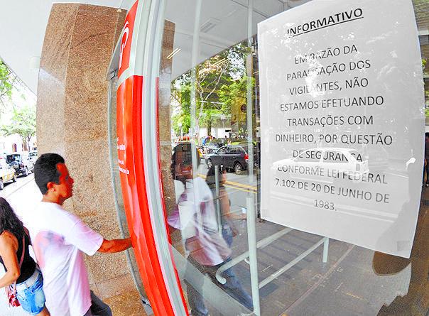 Aviso na porta de agência bancária indica restrição dos serviços (Antonio Trivelin/AAN)
