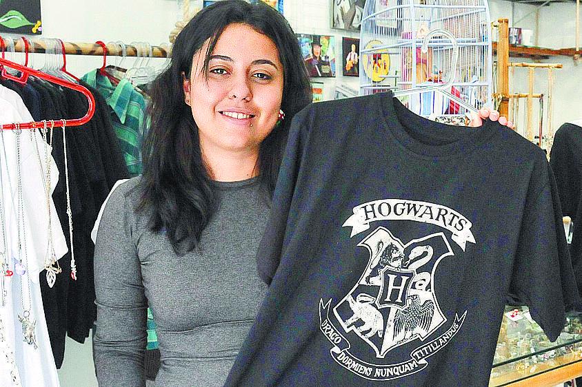 Polyana Francisco de Rezende, da loja Dixie Arte e Estilo, mostra camiseta alusiva à série Harry Potter (Leandro Ferreira)