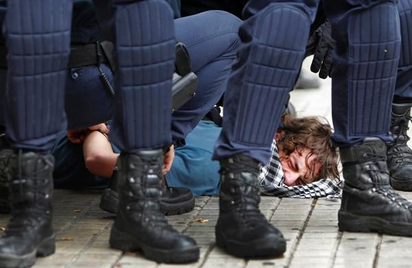 Imigrante é detido por policiais durante protesto na Grécia (France Press)