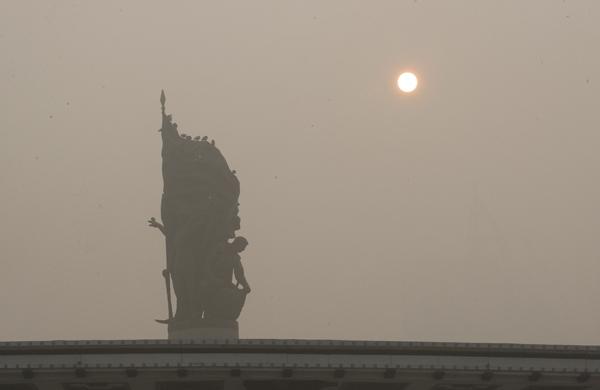Estátua fica encoberta por nuvem de poluição na China (France Press)
