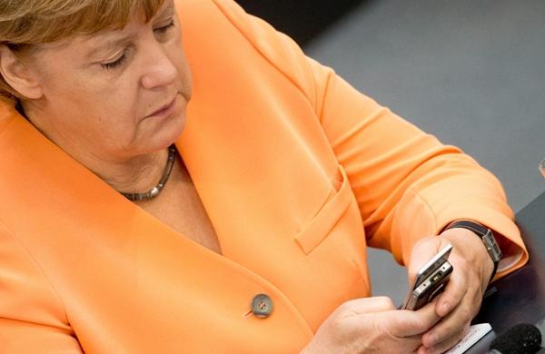 Angela Merkel observa aparelho celular supostamente espionado pelos EUA (France Press)