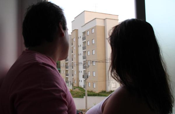 Giovan e Eliete Restani da janela de seu apartamento que tiveram de alugar no mesmo condom&iacute;nio, enxergam o pr&eacute;dio embargado onde deveriam estar morando desde 2011: empresa promete libera&ccedil;&atilde;o (Camila Moreira/ AAN)