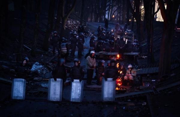 Policiais ucranianos enfrentam o frio pr&oacute;ximo a barricada montada por manifestantes (France Press)