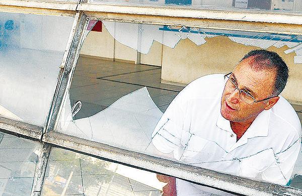 O m&eacute;dico Ronaldo Ribeiro de Melo, visto atrav&eacute;s da janela com vidro quebrado ap&oacute;s confus&atilde;o no PA Campo Grande, afirma que paciente foi prontamente atendido (Dominique Torquato /AAN)