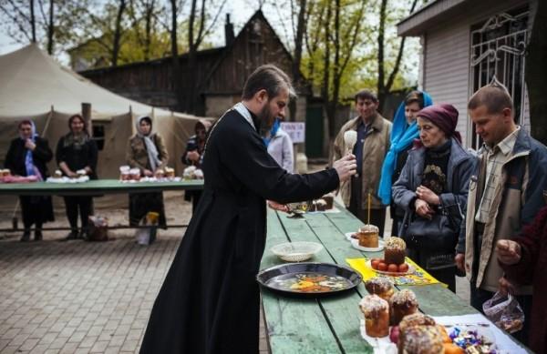 Padre ortodoxo aben&ccedil;oa alguns ovos, seguindo a tradi&ccedil;&atilde;o religiosa (France Press)