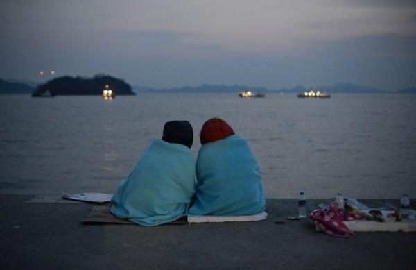Parentes das v&iacute;timas do naufr&aacute;gio na Coreia do Sul est&atilde;o na praia acompanhando resgate dos corpos (France Press)