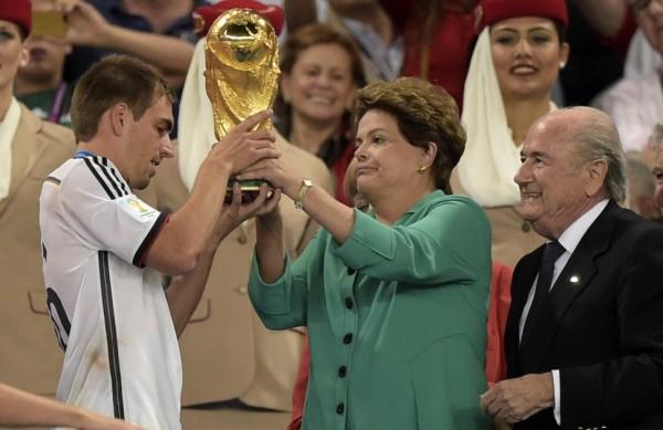 Dilma entre a ta&ccedil;a para o capit&atilde;o alem&atilde;o Philipp Lahm ao lado de Joseph Blatter (AFP)
