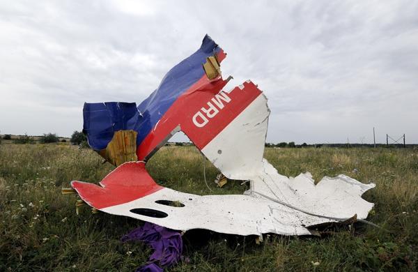 Parte da fuselagem do avi&atilde;o malaio em solo ucraniano ap&oacute;s ser abatido (France Press)