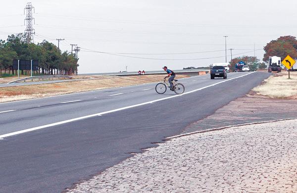 Ciclista se arrisca na Rodovia Zeferino Vaz, a mesma estrada onde duas mulheres morreram atropeladas por uma motocicleta no in&iacute;cio de junho ( Gustavo Tilio/Especial para a AAN)