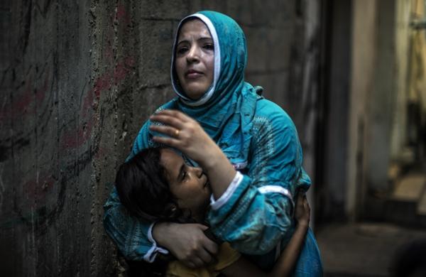 M&atilde;e e filha palestinas procuram abrigo na Faixa de Gaza ap&oacute;s bombardeio de Israel (France Press)