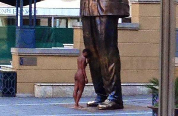 Foto postada no Twitter mostrou a mulher nua, com a cabe&ccedil;a inclinada contra o joelho da est&aacute;tua (Reprodução/ Twitter)