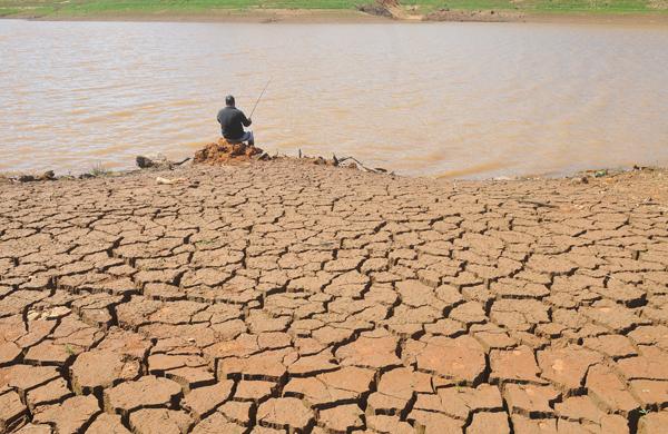 Homem pesca na represa do Jaguari, que abastece o Cantareira: a seca que atinge a região baixou o nível de água e causou rachaduras no solo (César Rodrigues/26mar2014/AAN )