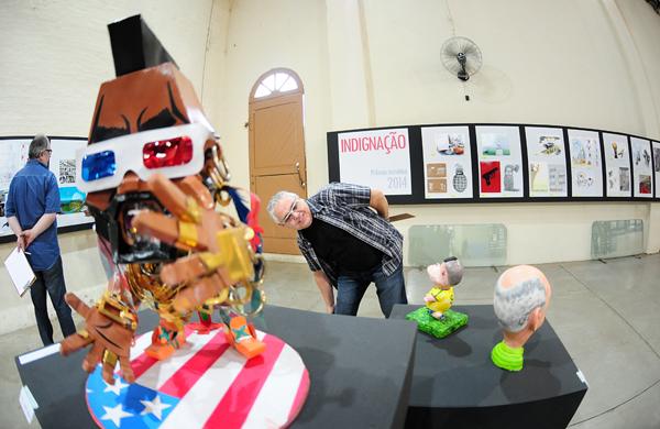 Jurado Luiz Carlos Fernandes observa obra exposta no Sal&atilde;o (Del Rodrigues/Gazeta de Piracicaba)