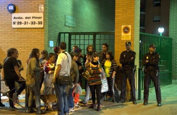 Algumas pessoas e a pol&iacute;cia montam guarda em frente &agrave; casa da enfermeira Teresa, em Madri, a primeira v&iacute;tima do Ebola fora da &Aacute;frica (France Press)