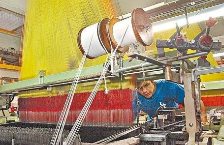 Funcion&aacute;rio observa m&aacute;quina em ind&uacute;stria do setor t&ecirc;xtil da RMC  ( Cedoc/ RAC)