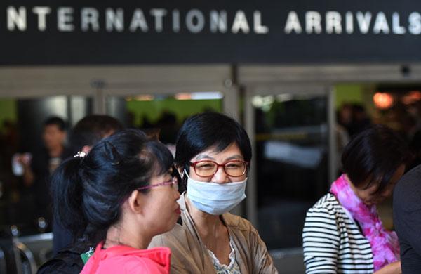 Passageiras usam m&aacute;scaras para tentar evitar a contamina&ccedil;&atilde;o pelo Ebola (AFP)