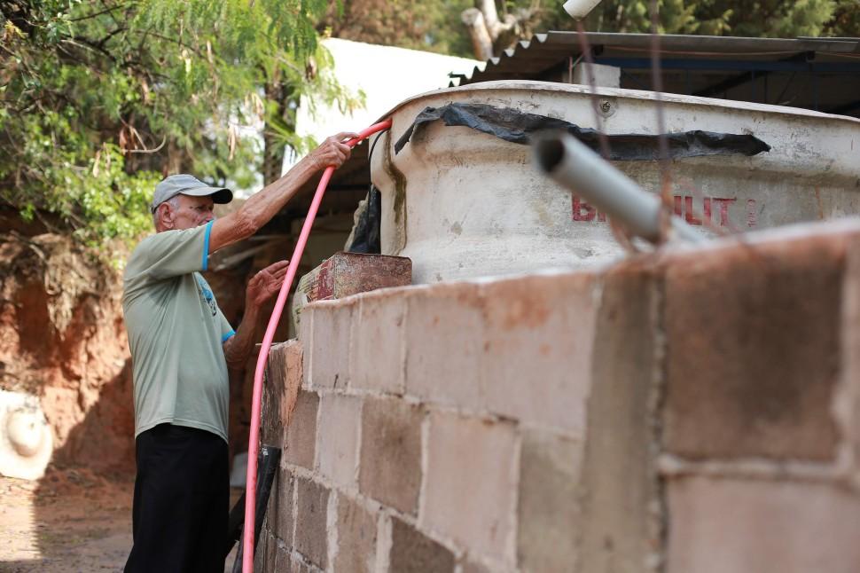 Francisco Fausto Leite Alves com cano que capta a &aacute;gua que vaza na rua para encher a caixa d?&aacute;gua de sua casa: ajuda aos vizinhos ( Leandro Ferreira/AAN)