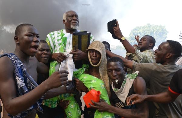 Manifestantes carregam parlamentar oposicionista ap&oacute;s aren&uacute;ncia do presidente de Burkina Faso, Blaise Compaor&eacute; (France Press)