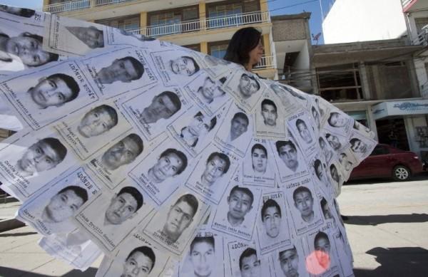 Mexicana participa de protesto com vestimenta formada pelas fotos dos estudantes desaparecidos - supostamente assassinados (France Press)